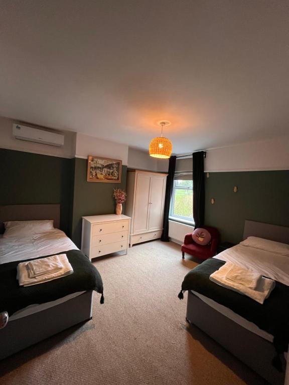 1 dormitorio con 2 camas y ventana en Millwright Villa - sleeps 7 en Lincolnshire