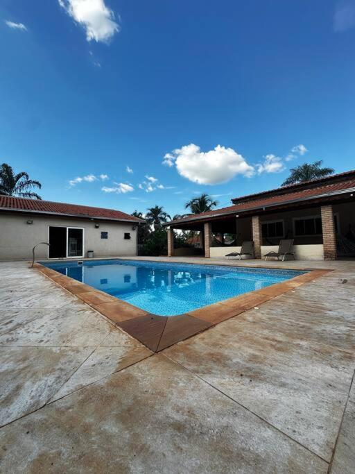 a swimming pool in front of a house at Casa de Campo Chácara Divisa Rio Preto e Guapiaçu in Sao Jose do Rio Preto