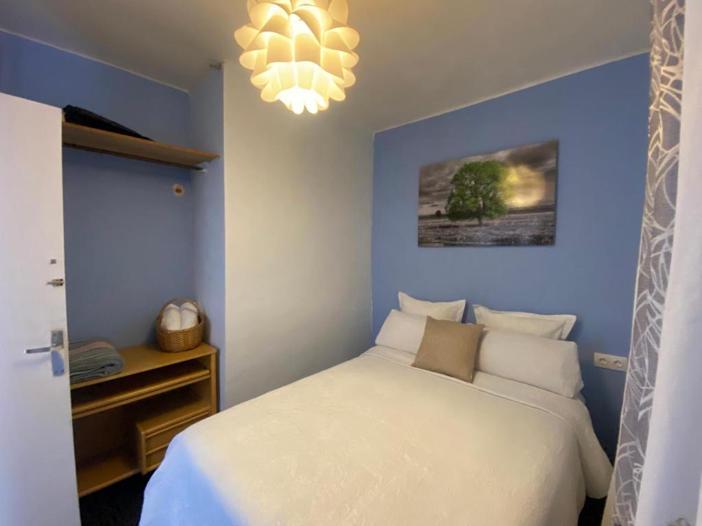 sypialnia z białym łóżkiem i żyrandolem w obiekcie LA CASA DE LAS HADAS w mieście La Reguda