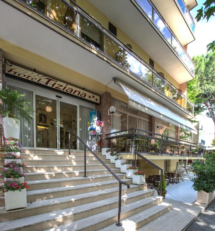 a building with stairs in front of a restaurant at Hotel Tiziana in Rimini