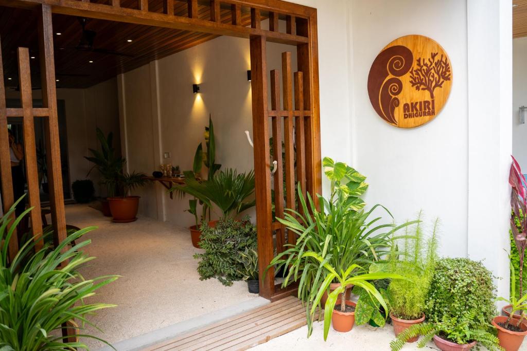 - l'accès à une pièce avec des plantes en pot dans l'établissement Akiri Dhigurah, à Dhigurah