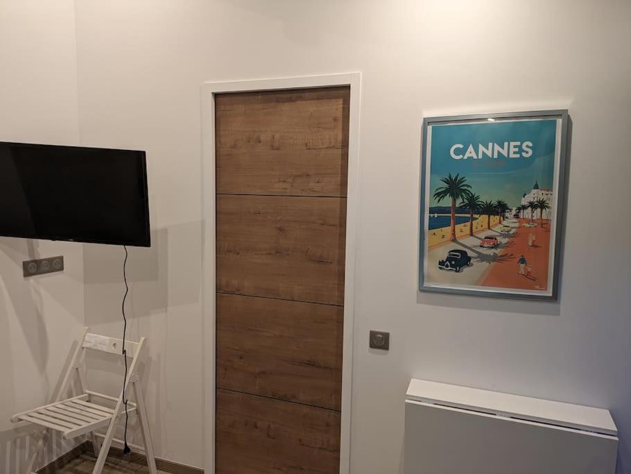 Cette chambre dispose d'une porte en bois et d'une télévision. dans l'établissement Chambre indépendante à mougins, à Mougins