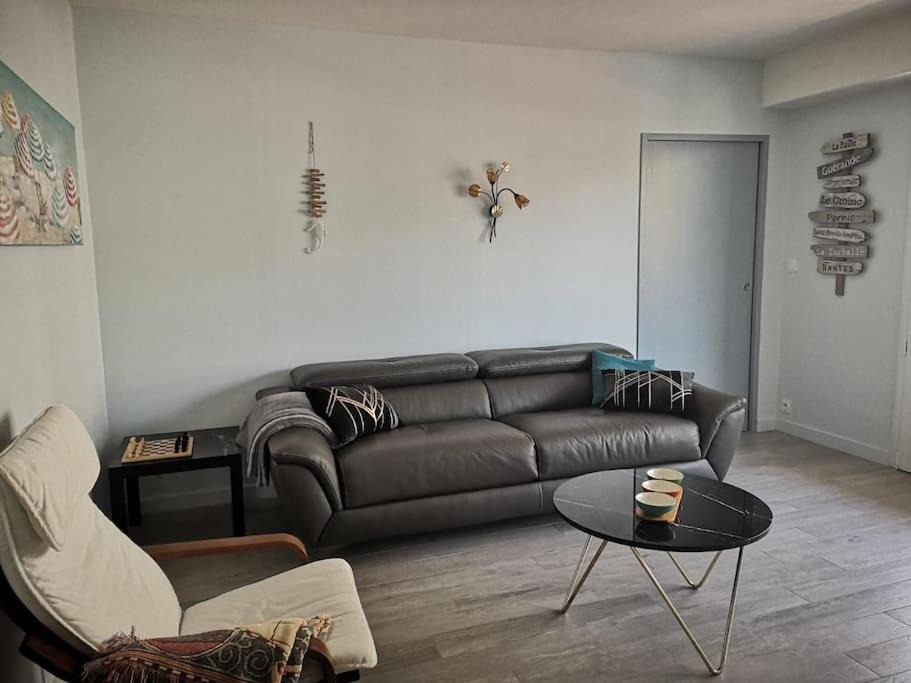 un salon avec un canapé en cuir et une table dans l'établissement Tout le charme de La Baule-Les -Pins T3 73m2, à La Baule