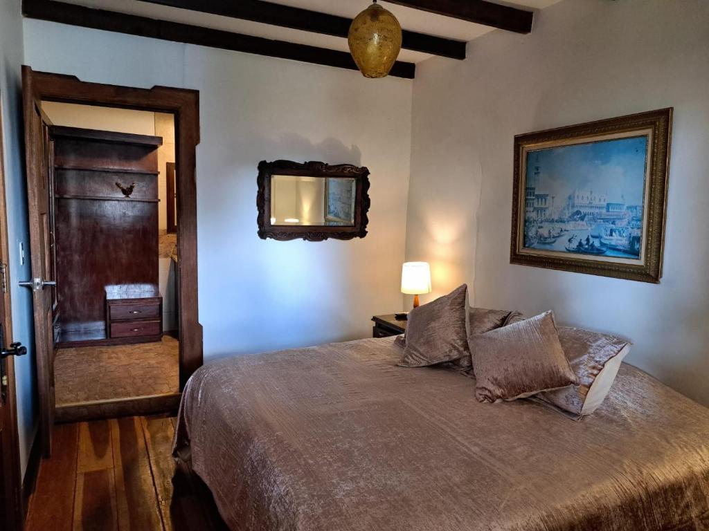 Schlafzimmer mit einem Bett und einem Wandspiegel in der Unterkunft Casa Lola Hotel Boutique in Salamina