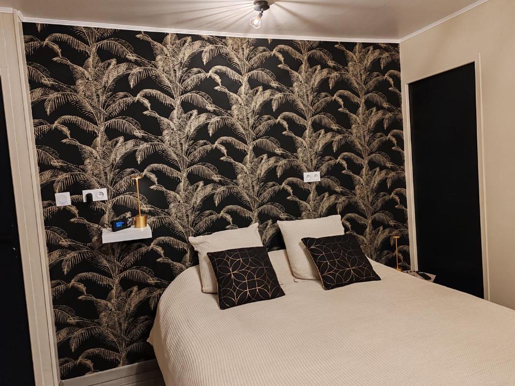- une chambre avec un grand lit et du papier peint noir et blanc dans l'établissement Hébergement proche aéroport de Nantes, à Saint-Aignan-Grand-Lieu