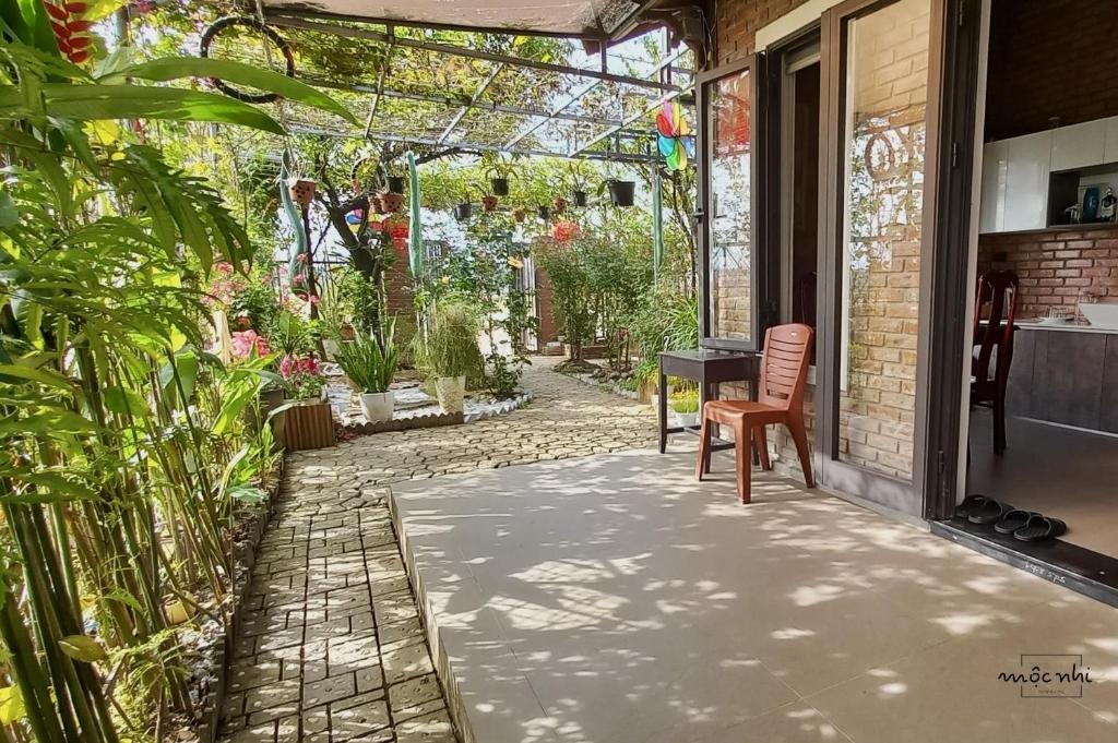 a patio with a table and chairs and plants at Homestay Mộc Nhi in Hue