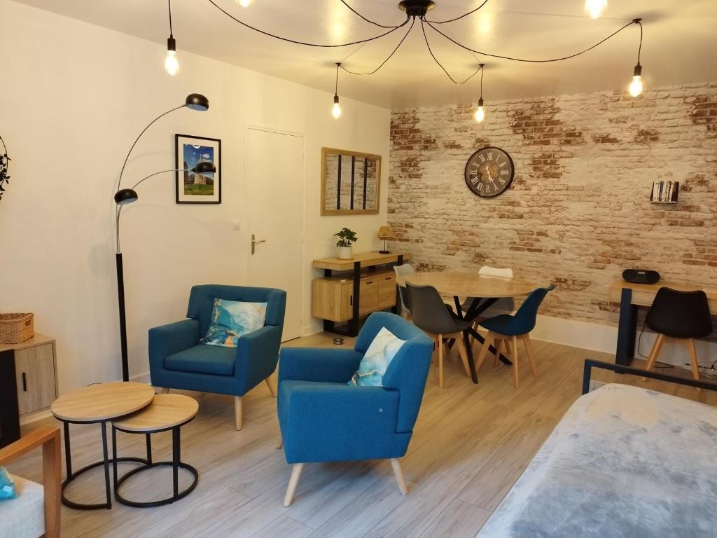 a living room with two blue chairs and a table at Appartement 2 pièces près des thermes in Bagnoles de l'Orne