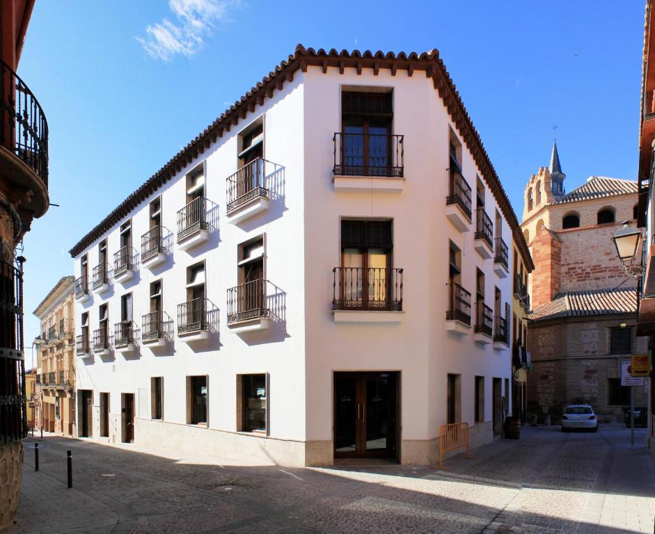 um edifício branco com varandas numa rua em Hotel La Casota em La Solana