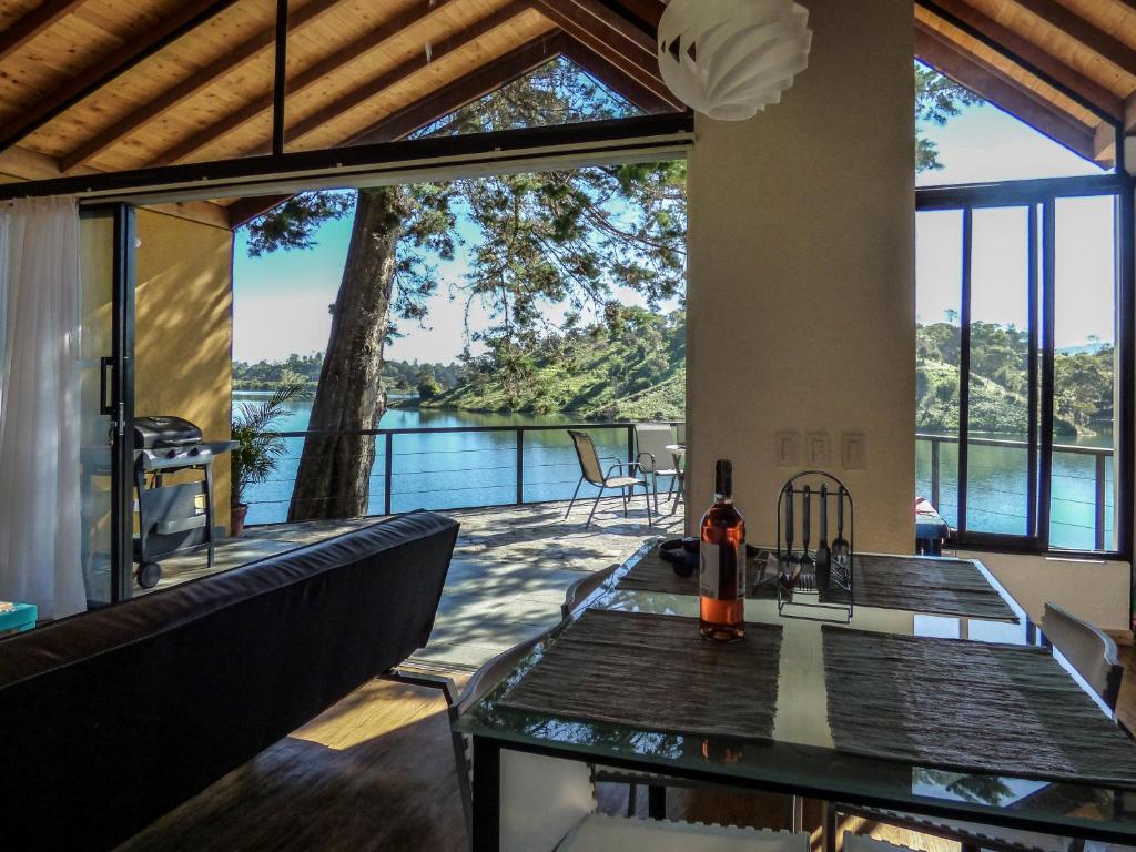 a view from the living room of a house with a table and chairs at Lodge in Guatapé, Cottage on the Lake with Jacuzzi in Guatapé