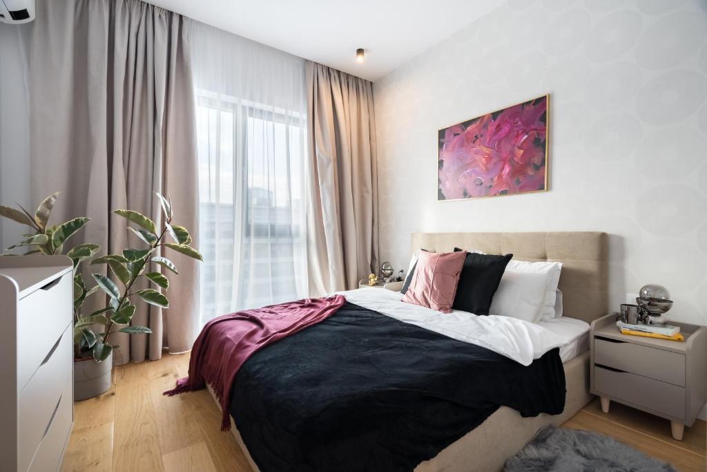 a bedroom with a bed and a large window at Cozy Business Area 1BR near Aviatiei in Bucharest