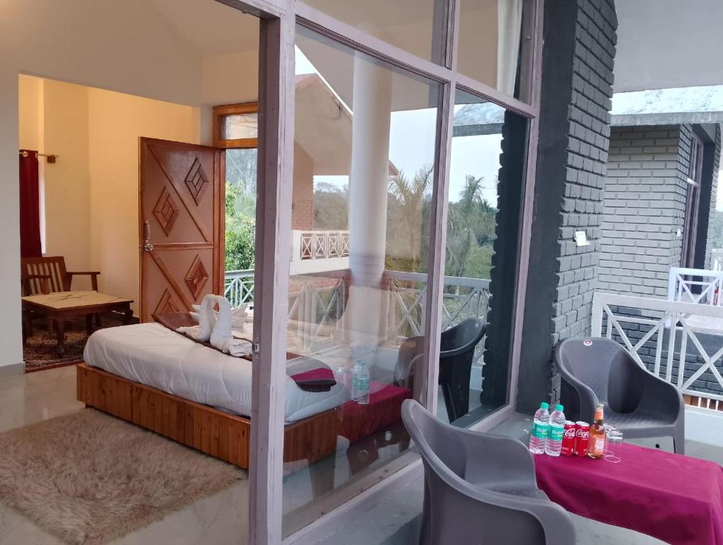 a room with a bed and a balcony at The Farmerian Resort in Belparāo