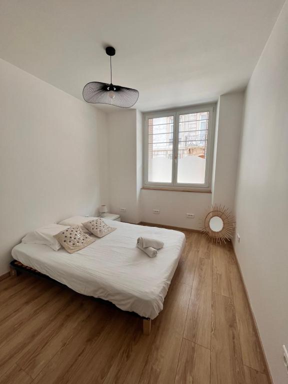 a white bedroom with a bed and a window at F3 On Saint-Vit ! in Saint-Vit