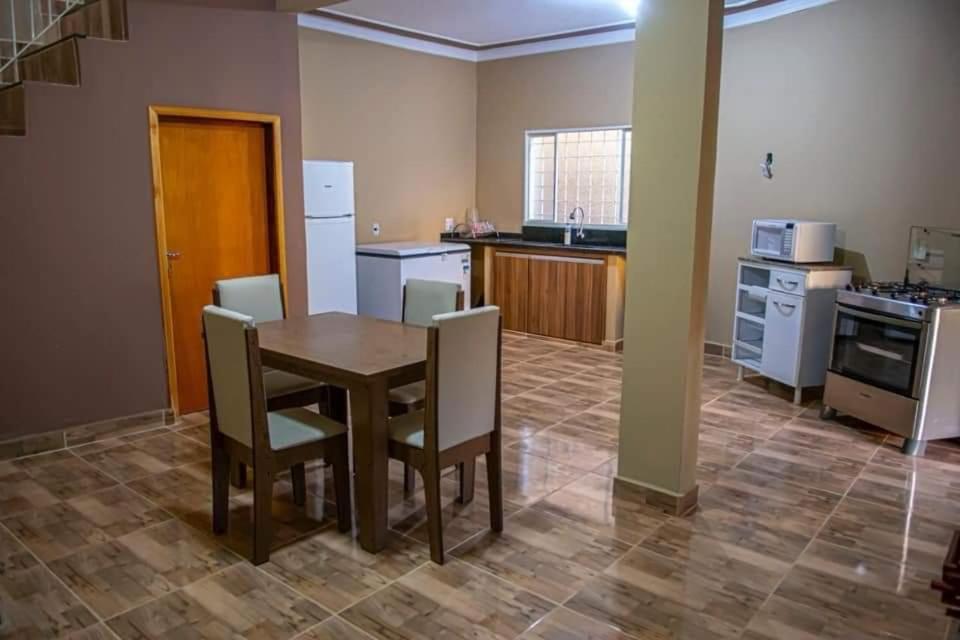 a kitchen with a table and chairs in a room at Area de lazer Santa Fé in Jardinópolis