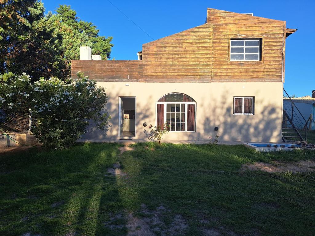 a house with a grass yard in front of it at Complejo Pino Azul in General Roca