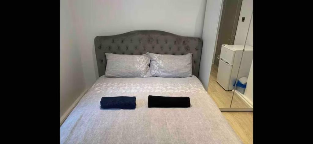 a bed with a headboard and two pillows on it at Budget Central London room 3 in London