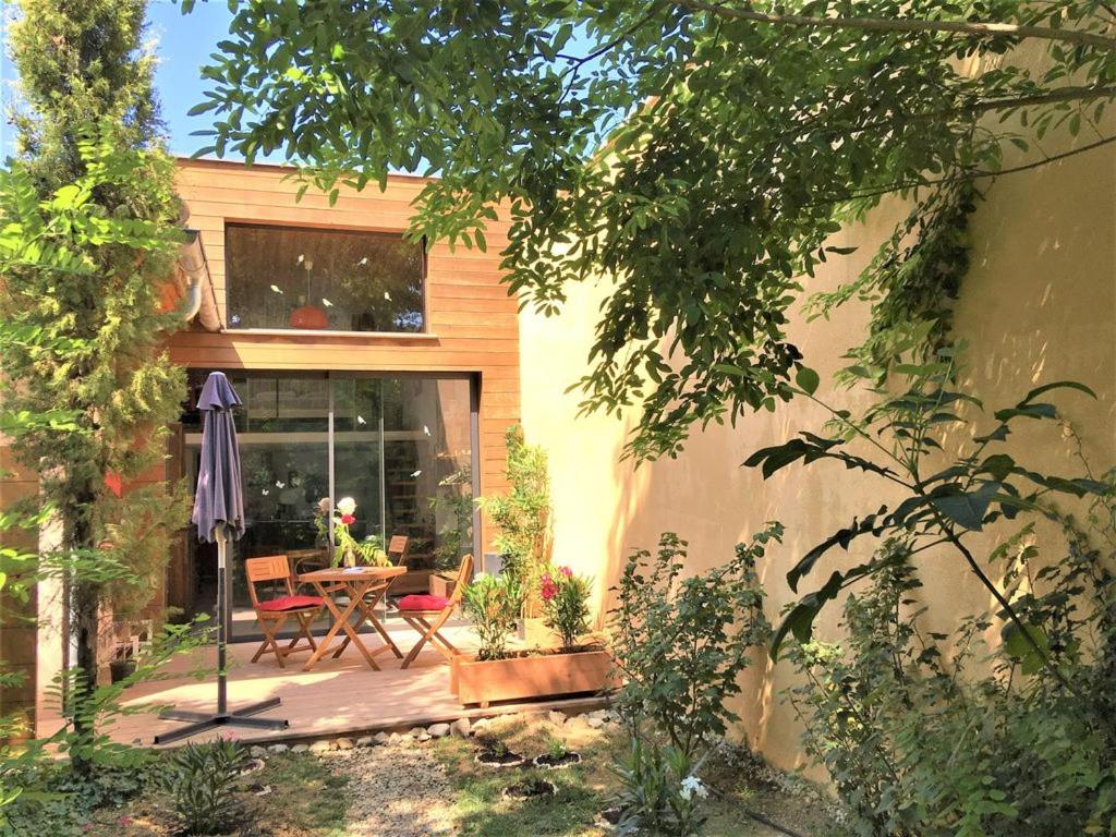 un patio avec une table et des chaises devant une maison dans l'établissement La PROVENCETTE, maison BIEN ÊTRE à 2 pas du centre ville, à Vaison-la-Romaine