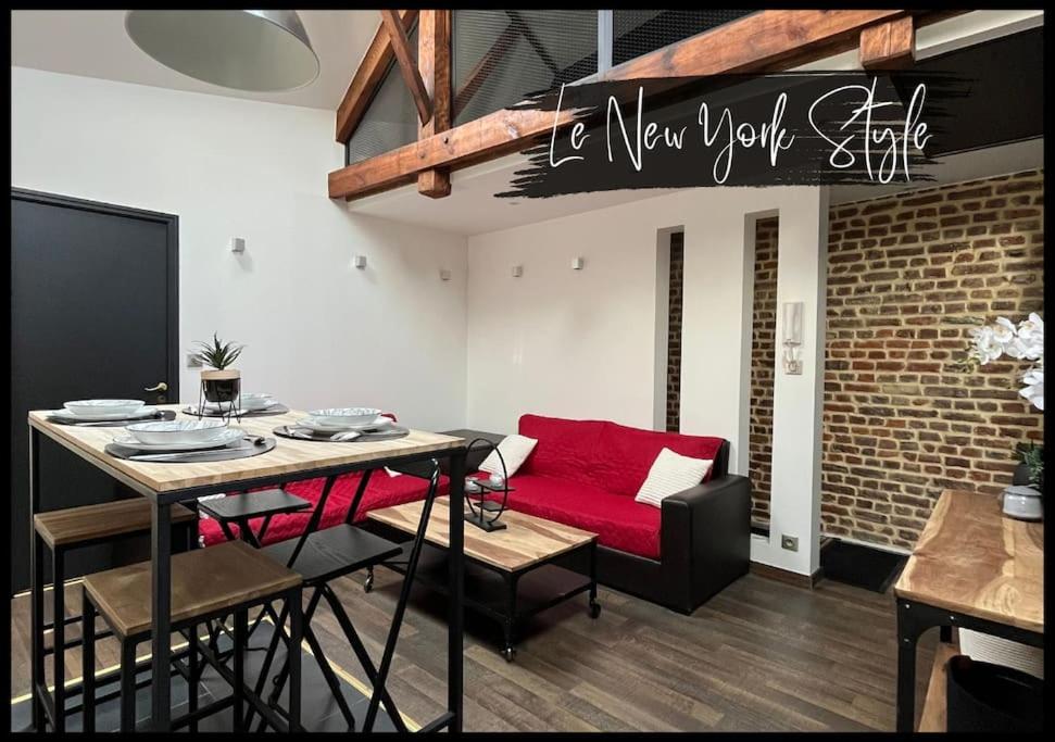 een woonkamer met een rode bank en een tafel bij 06. Le New york Style By Fanny .S in Saint-Quentin
