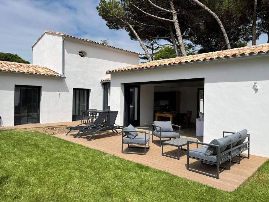 un patio con sillas y una mesa en Villa - proche plages/commerces, en Le Bois-Plage-en-Ré