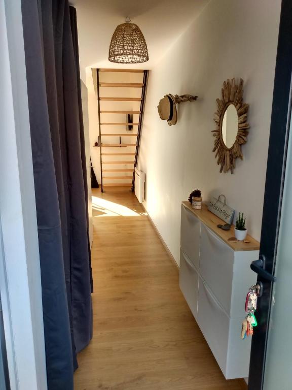 un couloir menant à une chambre avec une porte et un miroir dans l'établissement A louer maison à Mimizan plage chez benoit, à Mimizan