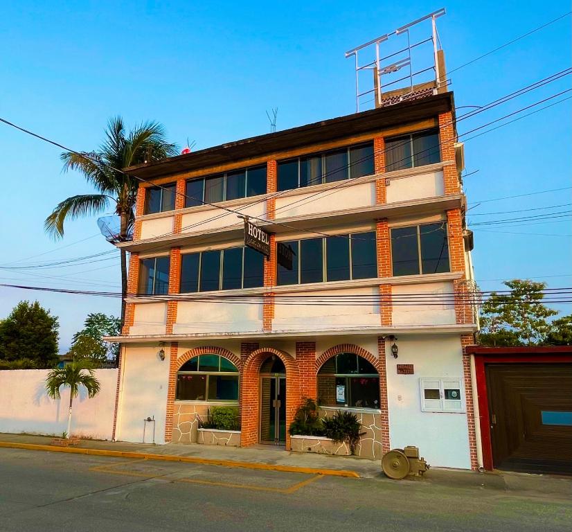 a tall building with a palm tree in front of it at Hotel Cosoleacaque Centro in Cosoleacaque