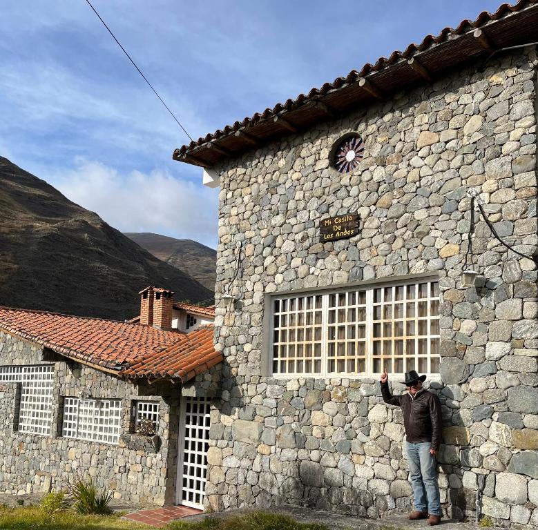 Un uomo in piedi di fronte a un edificio in pietra di Mi casita de Los Andes a San Rafael