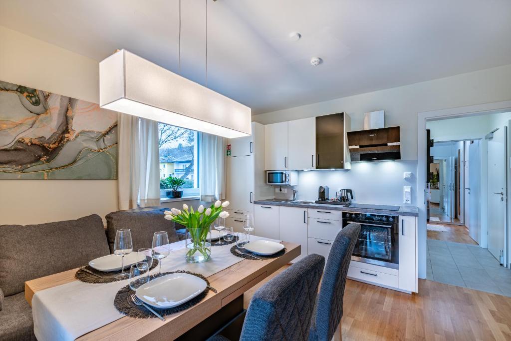 a kitchen and living room with a table and chairs at Well-Home Apartments Velden Top1 in Velden am Wörthersee