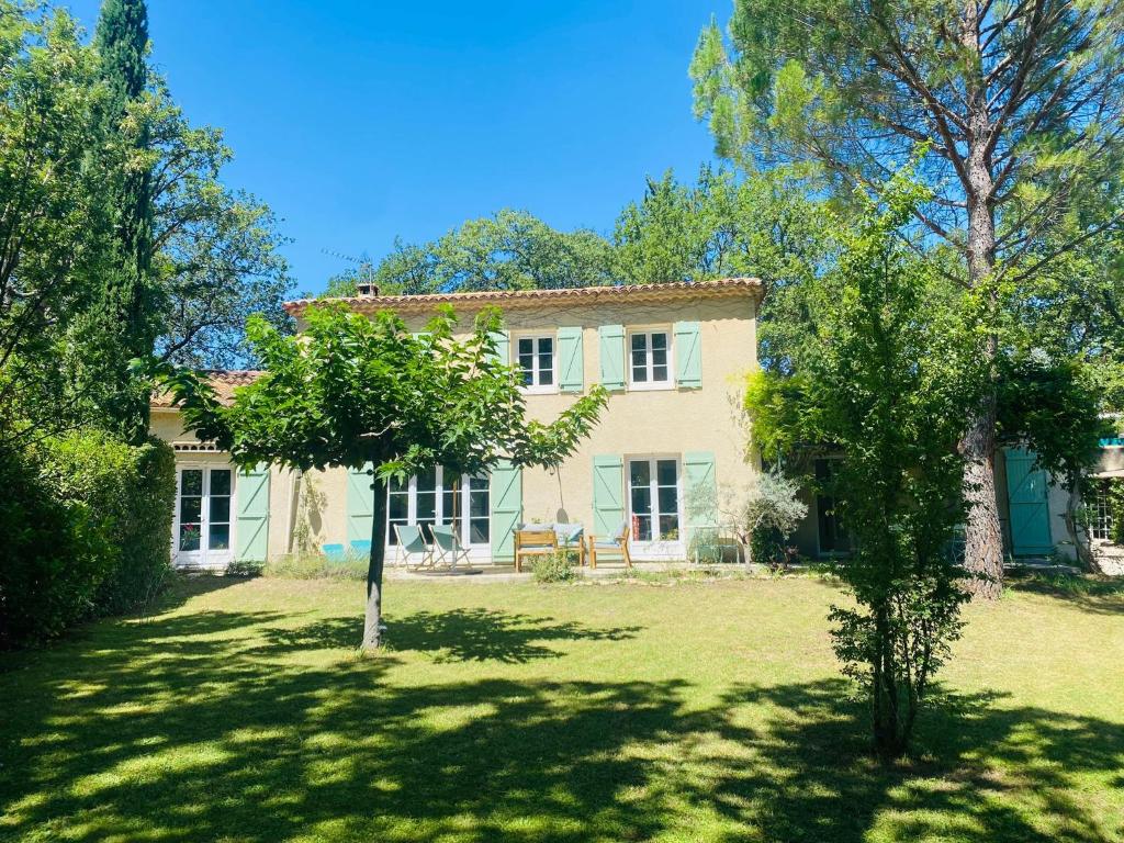 une maison avec une cour arborée devant elle dans l'établissement Magnifique villa avec jardin proche centre ville, climatisé, à Aix-en-Provence