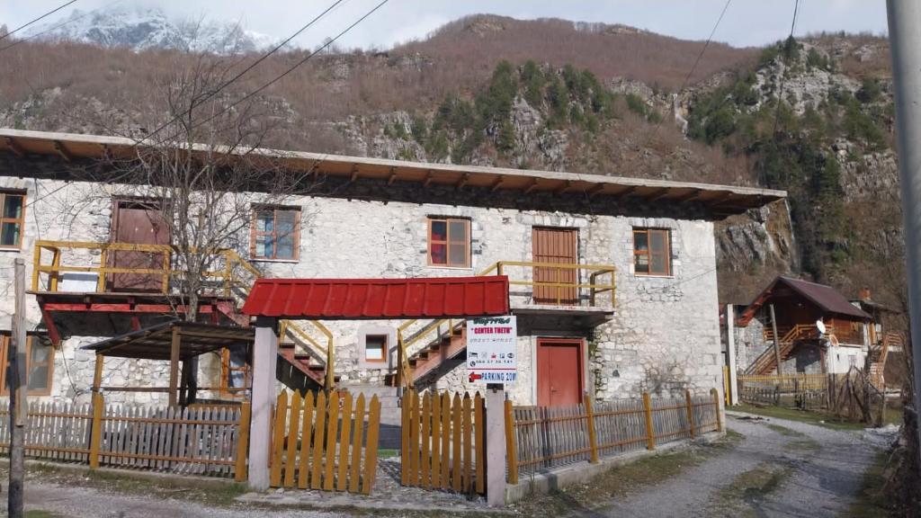un edificio bianco con una recinzione di fronte di GUEST HOUSE “ Center Theth “ a Theth