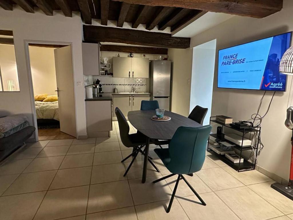 une cuisine et une salle à manger avec une table et des chaises dans l'établissement appartement F3, à Chalon-sur-Saône
