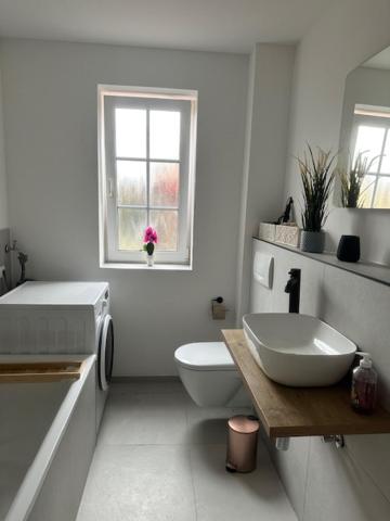 bagno bianco con lavandino e servizi igienici di Whg 4 Willkommen in unserer gemütlichen Ferienwohnung an der Ostsee! a Scharbeutz