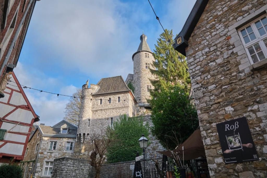 a large stone building with a tower at Historische Alte Mühle direkt an der Burg in Stolberg