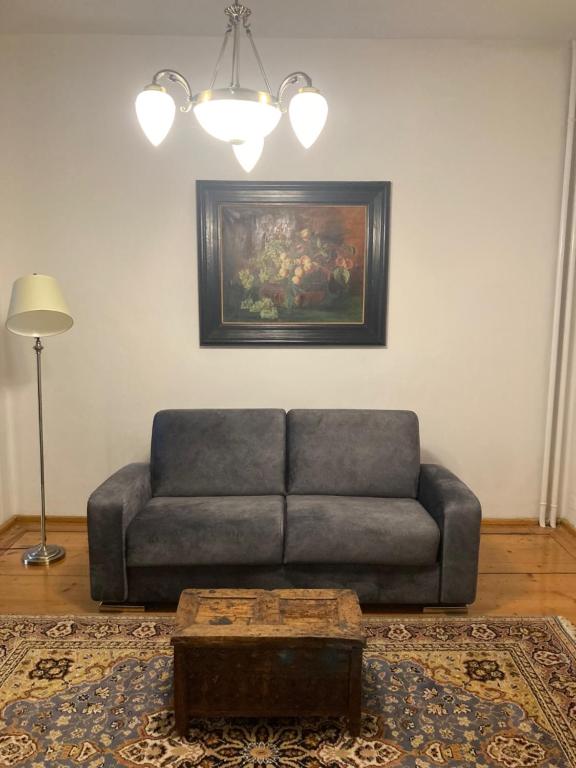 ein Wohnzimmer mit einem Sofa und einem Gemälde in der Unterkunft Wohnen um die Jahrhundertwende in Brixen