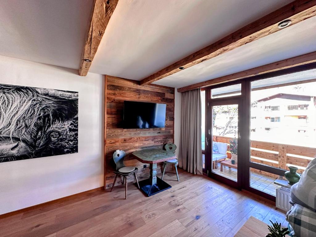 a room with a table and chairs and a television at Chalet Grubhof in Sankt Martin bei Lofer