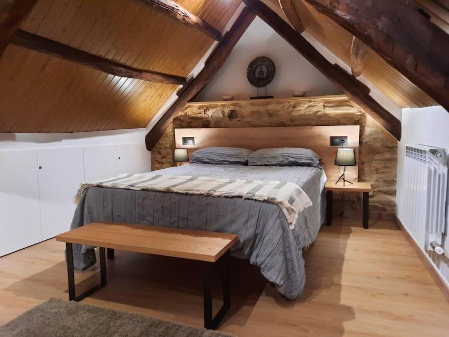 a bedroom with a large bed in a attic at El Regueron in Folgoso de la Ribera
