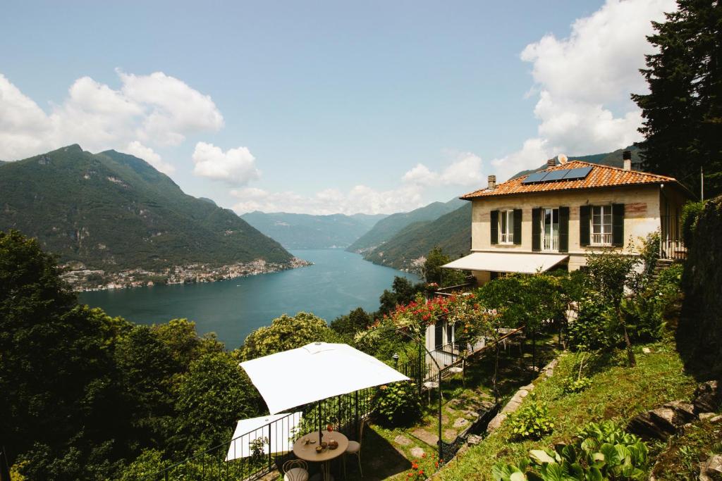 een huis op een heuvel met uitzicht op een meer bij B&B Villa le Ortensie in Faggeto Lario 