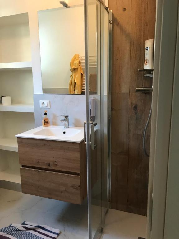 uma casa de banho com um lavatório e um chuveiro com um espelho. em Casa Lavinia al mare em Rimini
