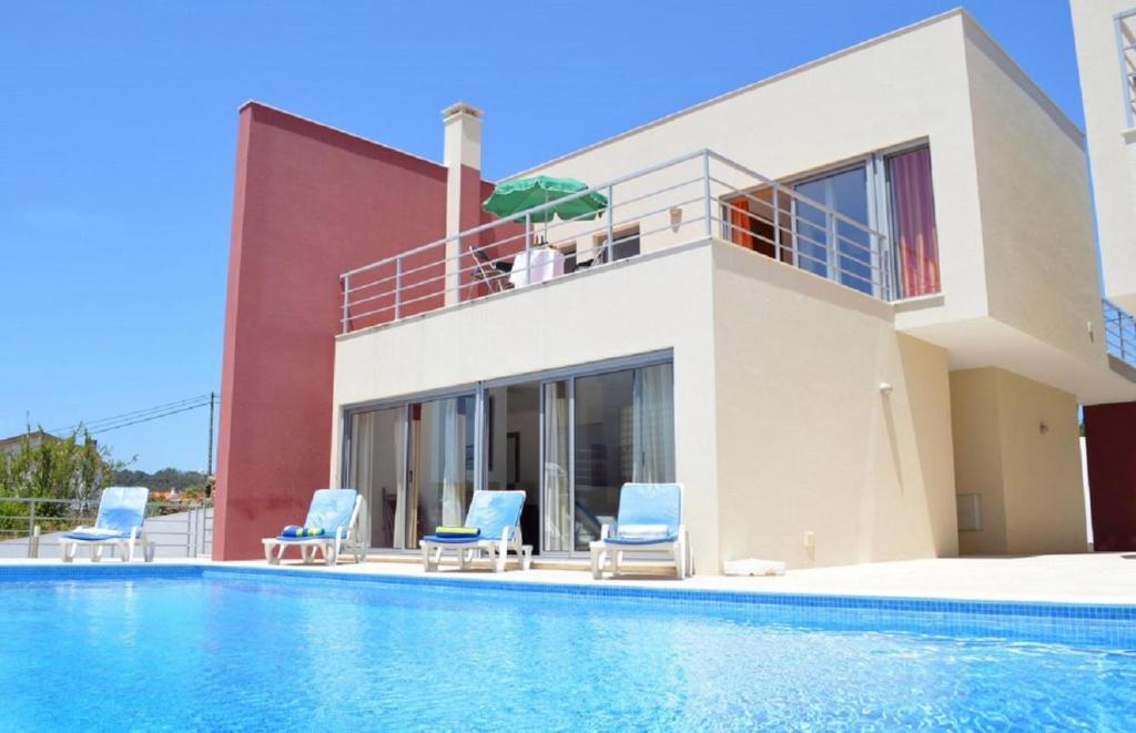 a house with chairs and a swimming pool at Foz Ocean Retreat in Foz do Arelho
