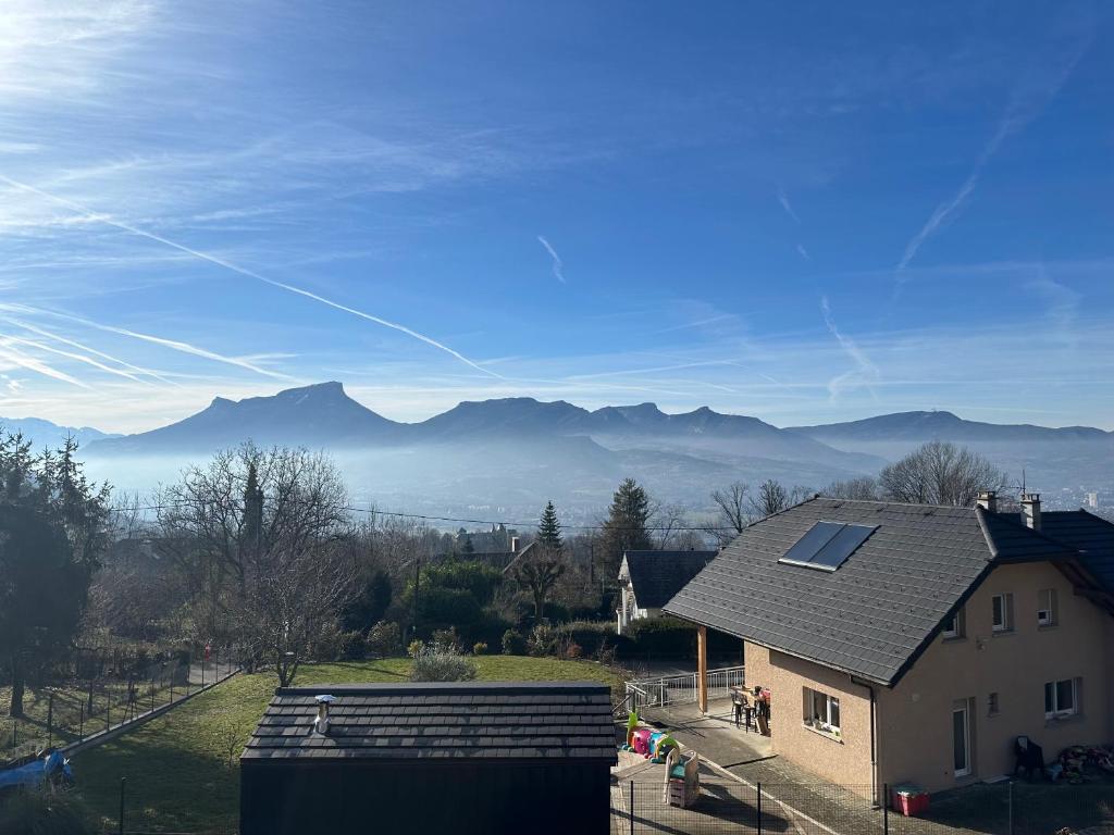 a house with a solar roof with mountains in the background at chambre au calme in Saint-Jean-dʼArvey