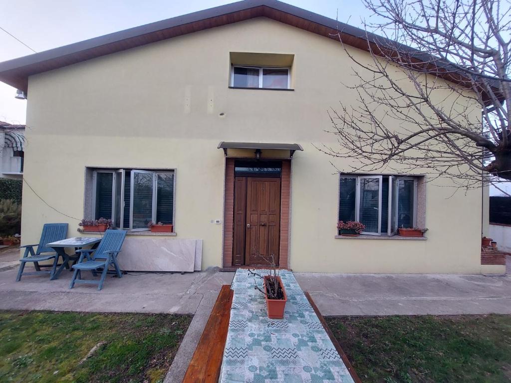 uma casa branca com uma porta de madeira e uma mesa em Carpe Diem em Treviso
