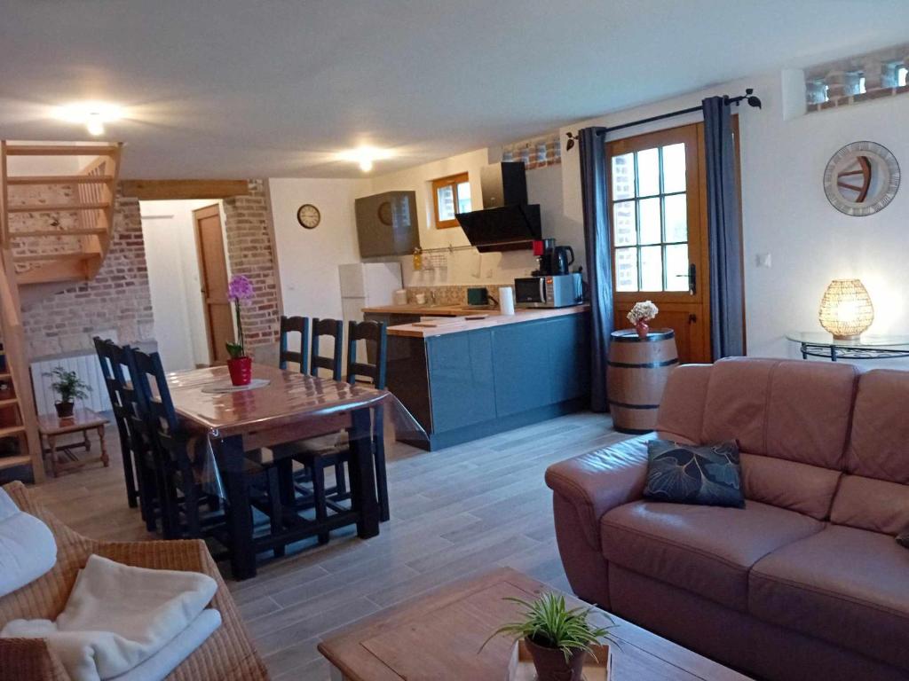 a living room with a couch and a table at Gite Ferme du Marronnier in Graincourt