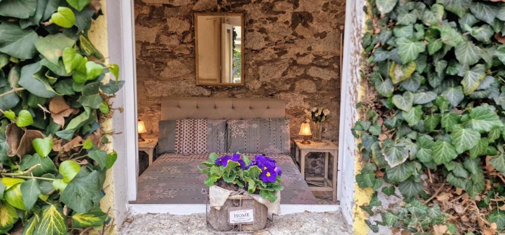 widok na pokój z łóżkiem i kwiatami w obiekcie The Cottage w mieście San Maurizio dʼOpaglio