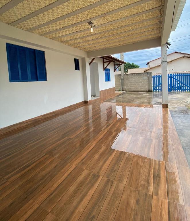 an empty room with a wooden floor in a house at Casa 2 Quartos 2 Suítes Castelhanos ES in Anchieta