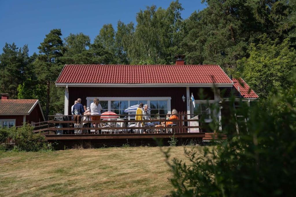 a group of people standing on a porch of a house at Mökki luonnon keskellä Espoossa in Espoo