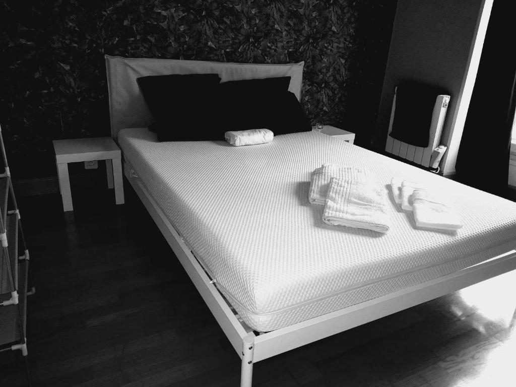 a black and white photo of a bed in a room at Belle Paris in Le Raincy