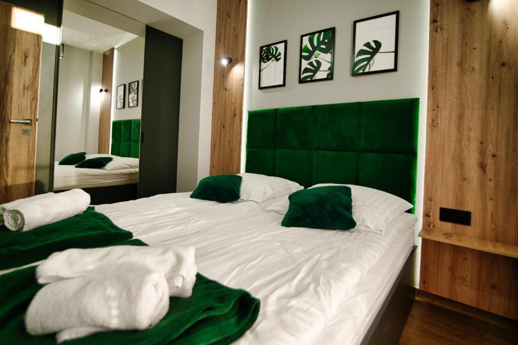 - une chambre avec un grand lit blanc et une tête de lit verte dans l'établissement Apartament No 34 Green - Holiday Home Zator, à Zator