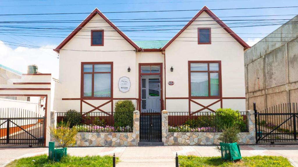 a white house with a fence at Hotel Albatros in Punta Arenas