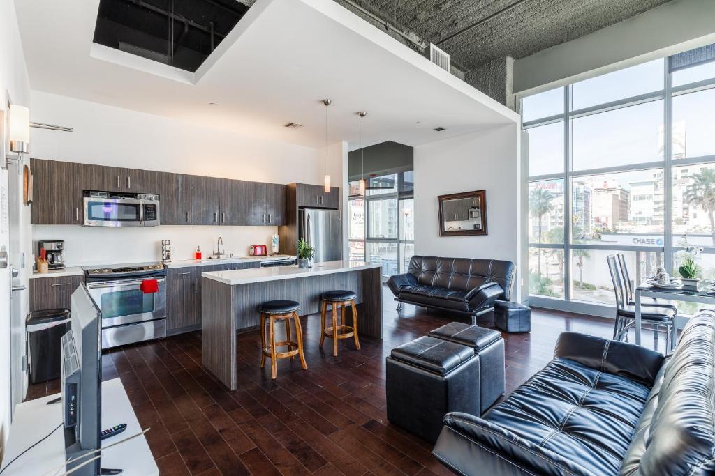 a kitchen and living room with a couch and a table at Fully Furnished Apartments near Hollywood Walk of Fame in Los Angeles