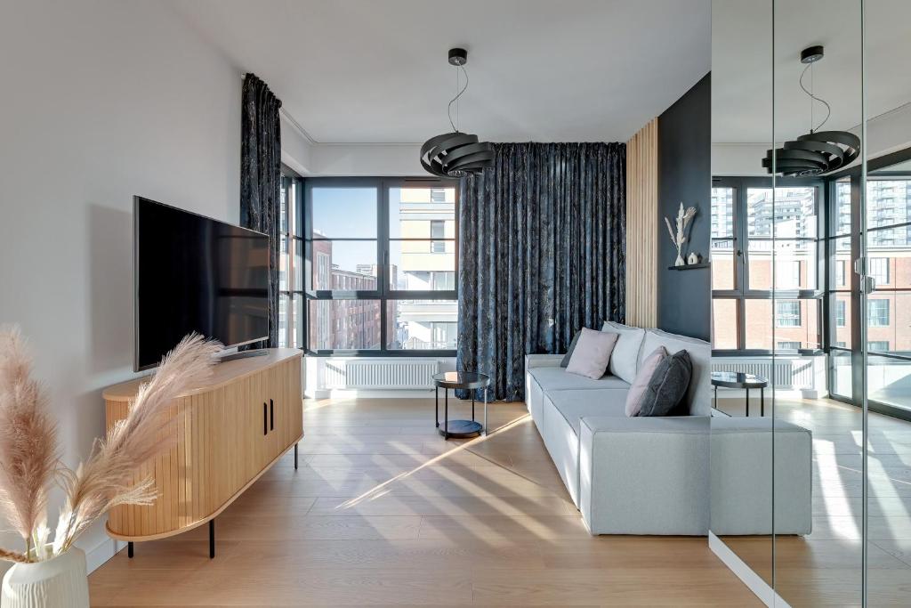 uma sala de estar com um sofá e uma televisão em Doki - Montownia View by Grand Apartments em Gdansk