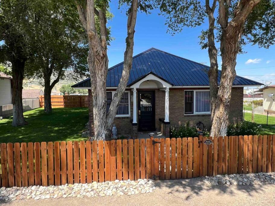 a wooden fence in front of a house with trees at The Ely Airbnb in Ely