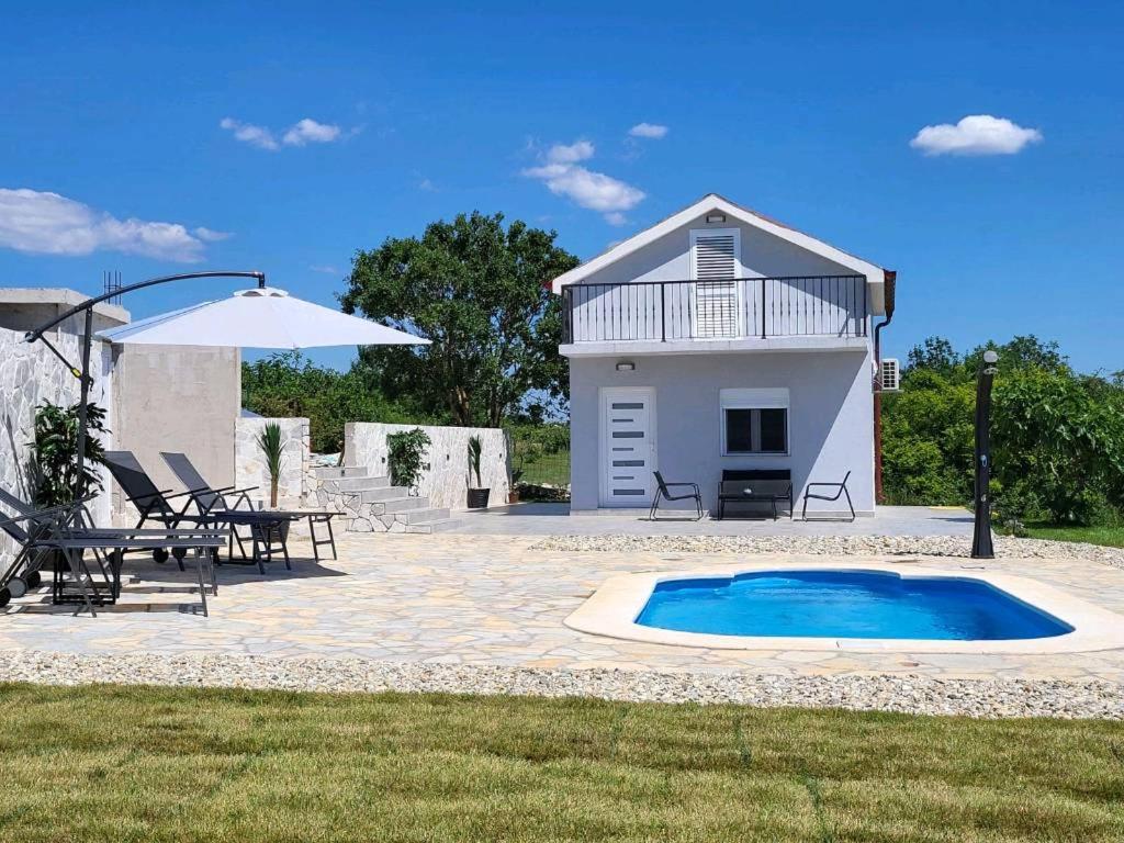 a patio with a swimming pool and a house at Villa Ana in Posedarje